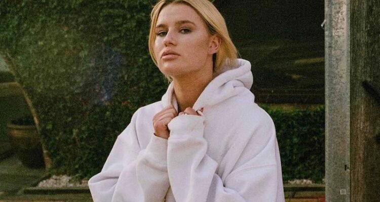 GRAACE takes a picture outside wearing a hoody