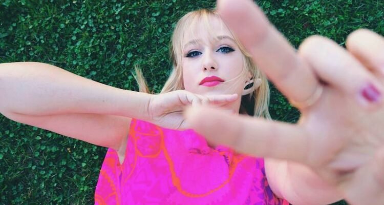 MAWD is laying down on green grass