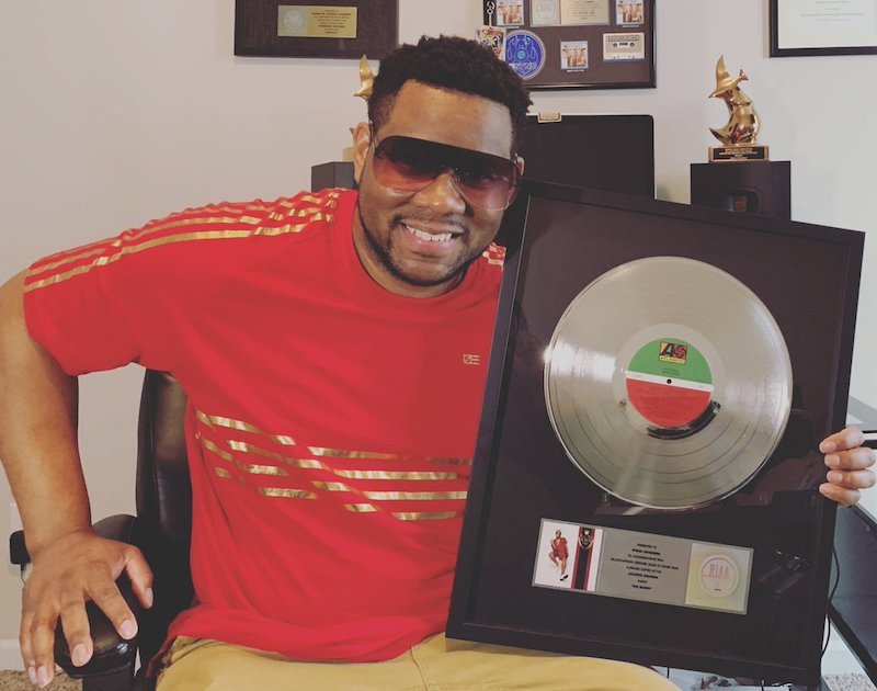 Mr. Talkbox press photo holding 3x's Platinum Plague for 24K Magic