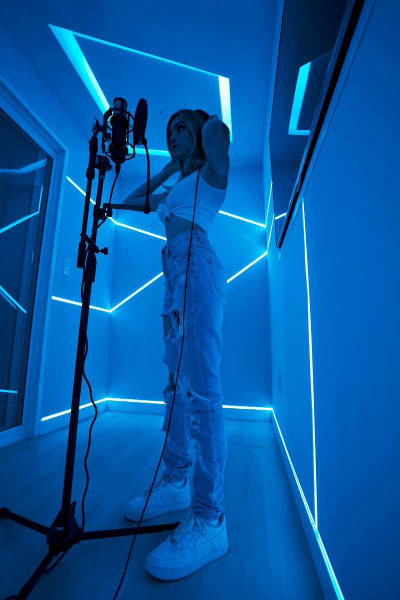 Sophia Gonzon press photo in the recording booth with blue background