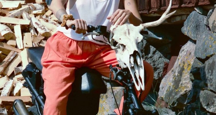 Elliphant - “Notorious” press photo sitting on a black motorbike with an animal skull attached to the handle bar.