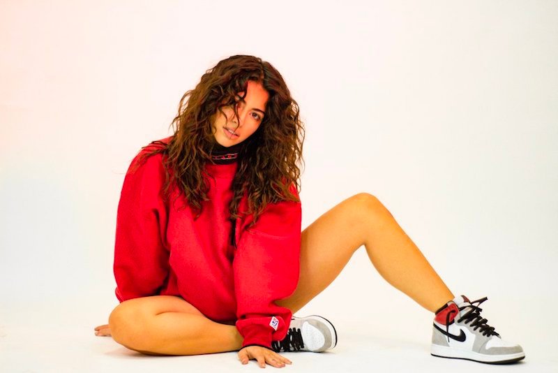 Laura Pieri press photo wearing a sweatshirt and Nike sneakers