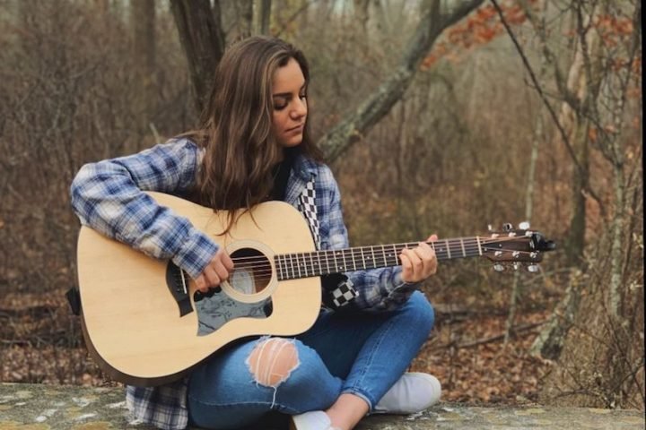 Nikolina Kiessling press photo outside playing the guitar