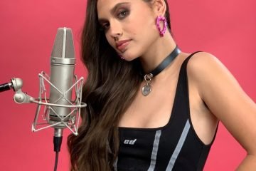 Ladi Rosa press photo standing in front of a microphone