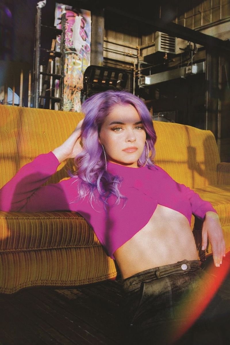 NIIVA press photo wearing a pink top and purple hair