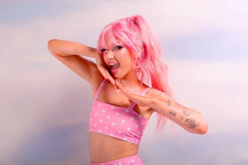 Peach PRC press photo wearing pink hair and pink and white outfit 