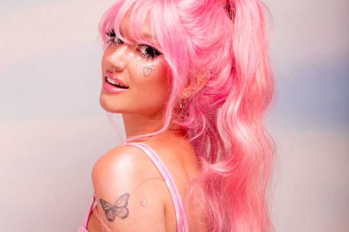 Peach PRC press photo wearing pink hair and pink and white outfit