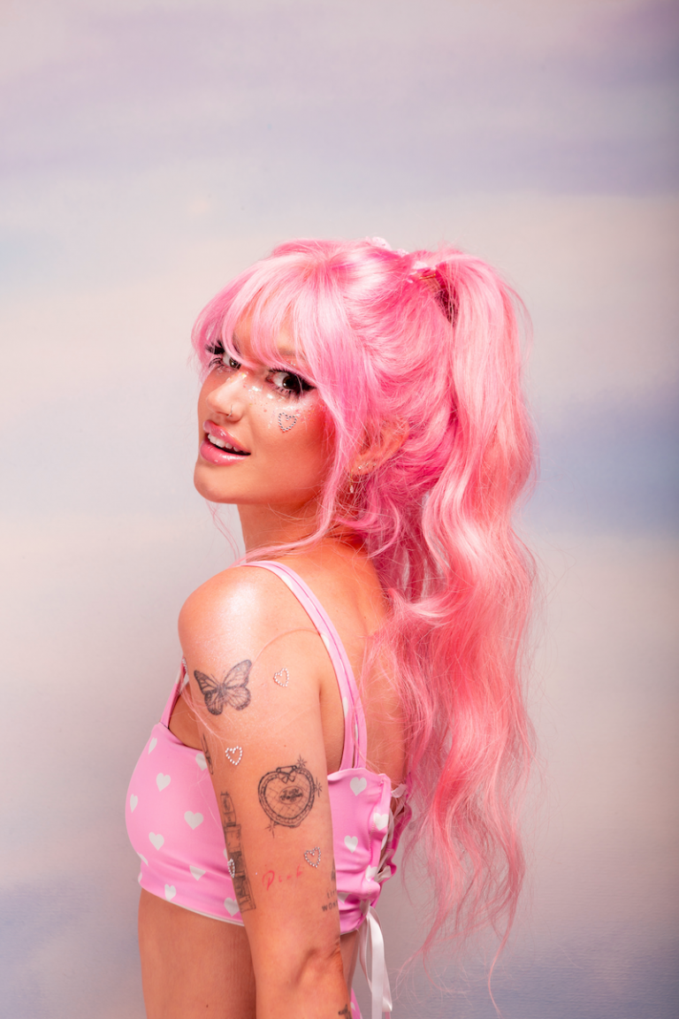Peach PRC press photo wearing pink hair and pink and white outfit