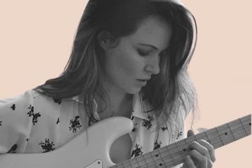 Jess Chalker press photo playing a guitar
