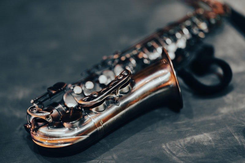 Silver saxophone on black surface 