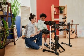 Woman teaching a boy how to play electric drums