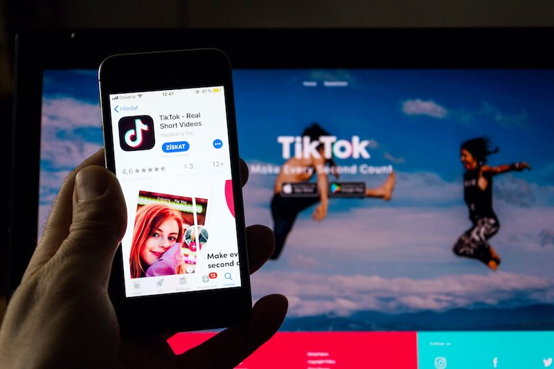 PRAGUE, CZECH REPUBLIC - NOVEMBER 22 2018: TikTok mobile video-sharing app company logo on phone screen with internet homepage in background on November 22, 2018 in Prague, Czech republic.