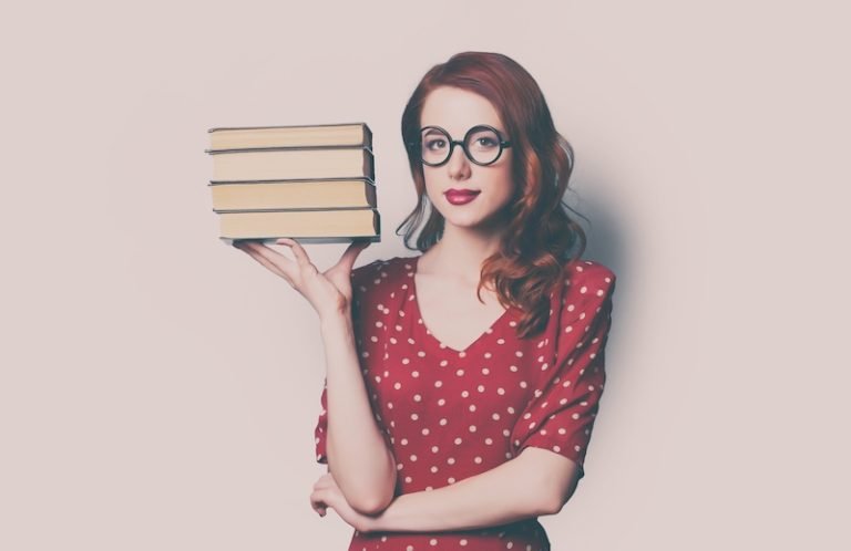 beautiful young woman with pile of books