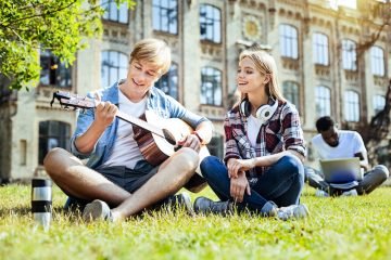 Talented young people playing guitar and smiling
