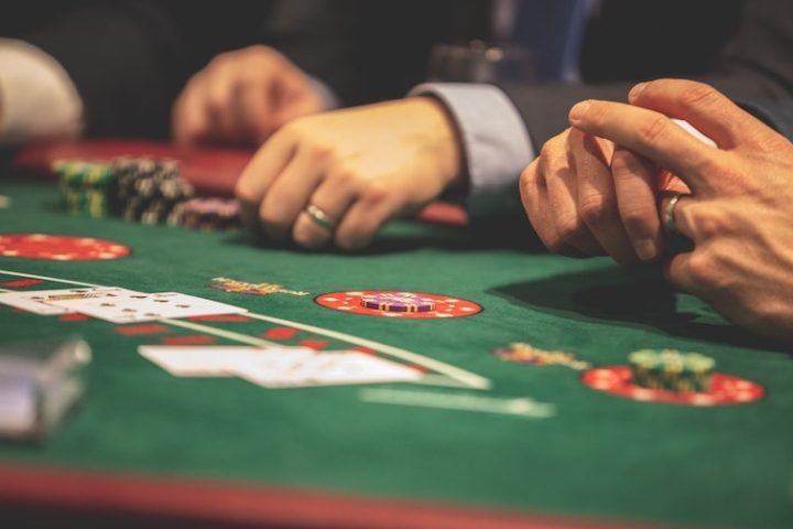 Men seated at a poker table, gambling