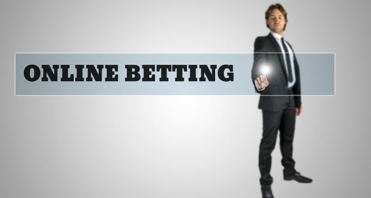 Young man in elegant suit activating Online betting button on virtual screen.